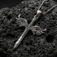 Load image into Gallery viewer, Oxidized Archangel Michael sword pendant on textured volcanic rock, macro close-up, winged crossguard detail, premium studio lighting
