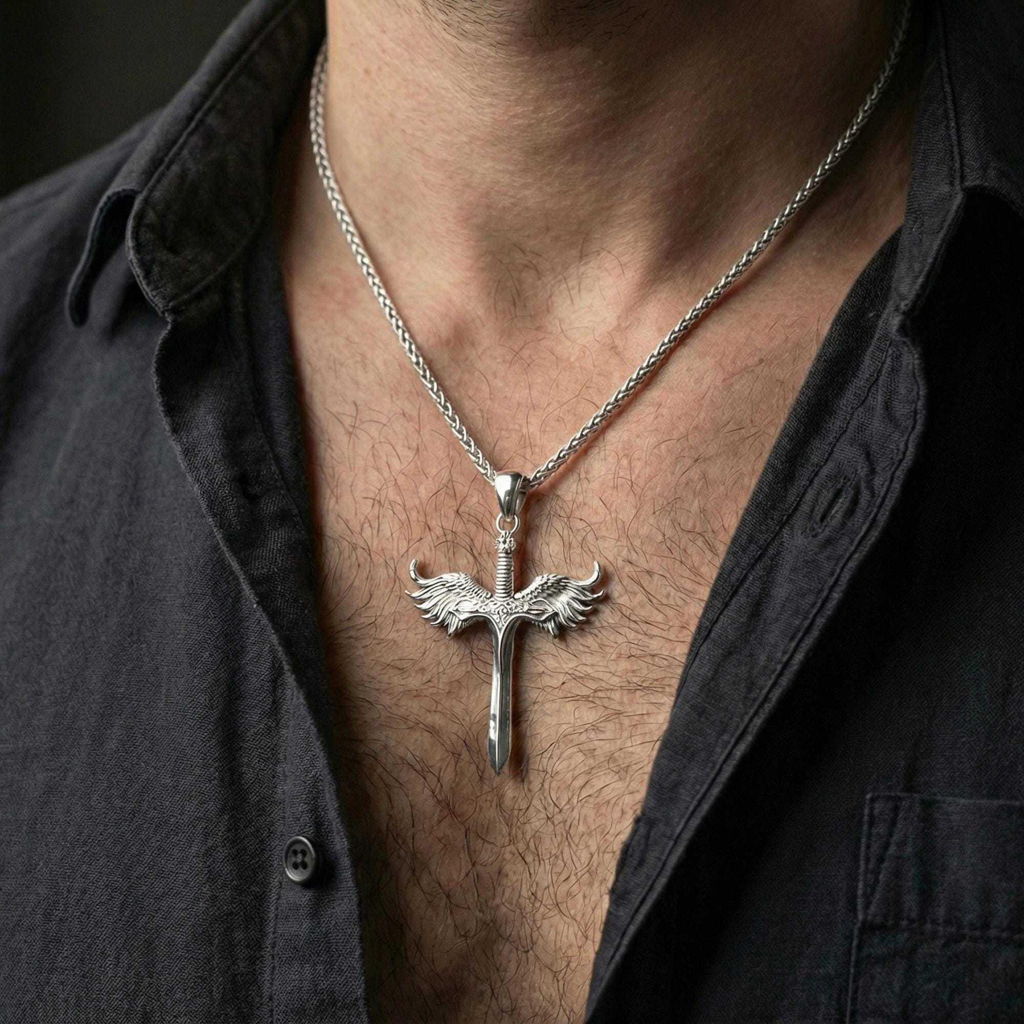 Polished silver Archangel Michael sword pendant on chain worn on neck, natural lifestyle framing, wings and blade clearly visible
