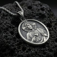 Load image into Gallery viewer, Oxidized Sacred Heart of Jesus pendant on textured volcanic rock, macro close-up, Jesus medal relief detail, premium studio lighting
