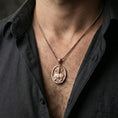 Load image into Gallery viewer, Rose gold plated Sacred Heart Jesus pendant necklace worn on neck, lifestyle composition with dark clothing, crisp round medallion silhouette
