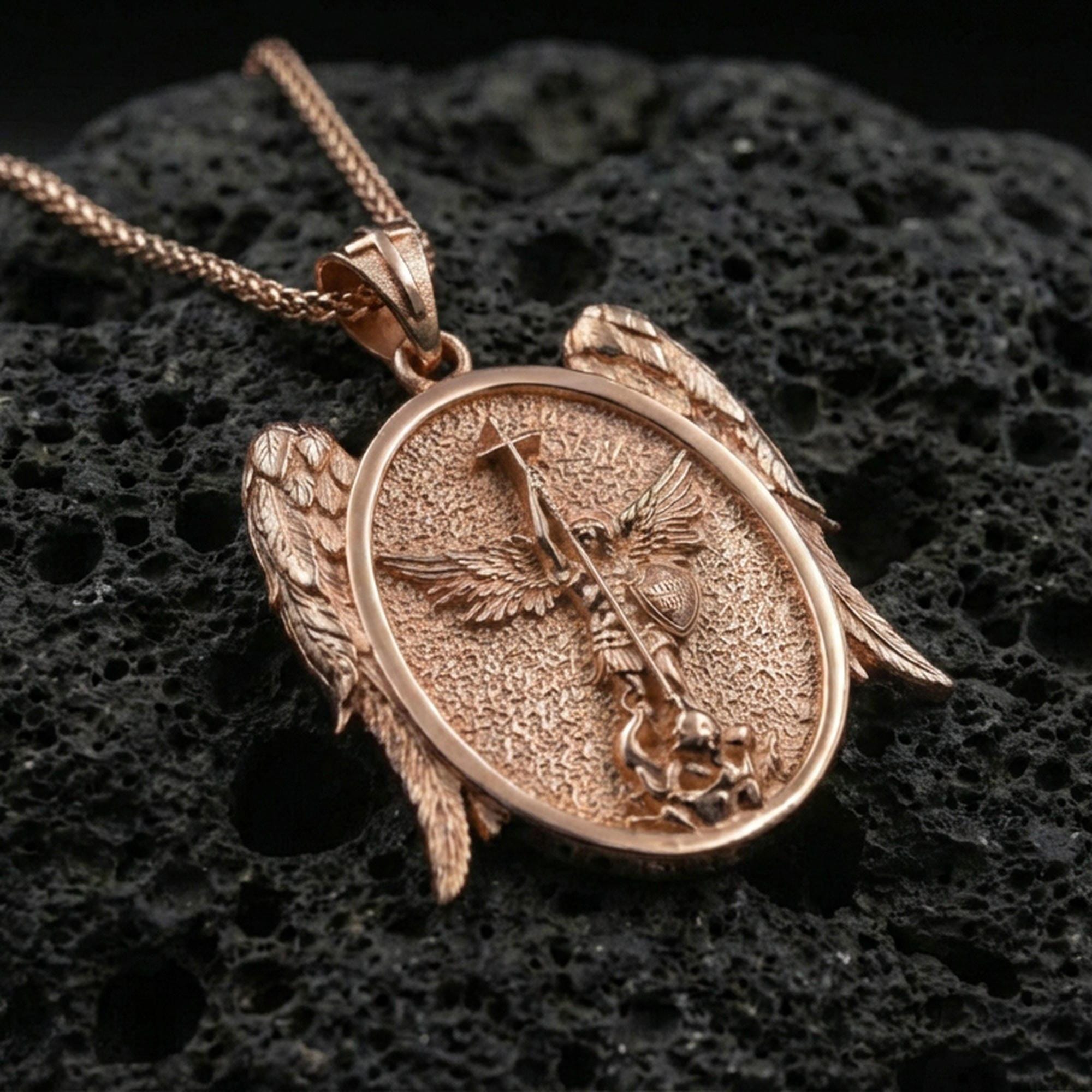 Rose gold plated Saint Michael religious pendant on volcanic rock, premium macro product photo, sharp relief and angel wing details