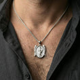 Load image into Gallery viewer, Polished silver Saint Michael pendant on chain worn on neck, natural lifestyle framing, archangel relief clearly visible
