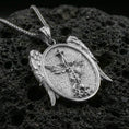 Load image into Gallery viewer, Polished silver Saint Michael necklace pendant on black volcanic stone background, crisp archangel relief with spear and shield, high-end product shot
