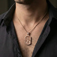 Load image into Gallery viewer, Rose gold plated Saint Andrew dogtag pendant necklace worn on neck, dark clothing lifestyle composition, rectangular pendant silhouette in focus
