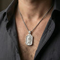 Load image into Gallery viewer, Polished silver Saint Andrew dogtag pendant on chain worn on neck, natural lifestyle framing, detailed apostle and cross visible
