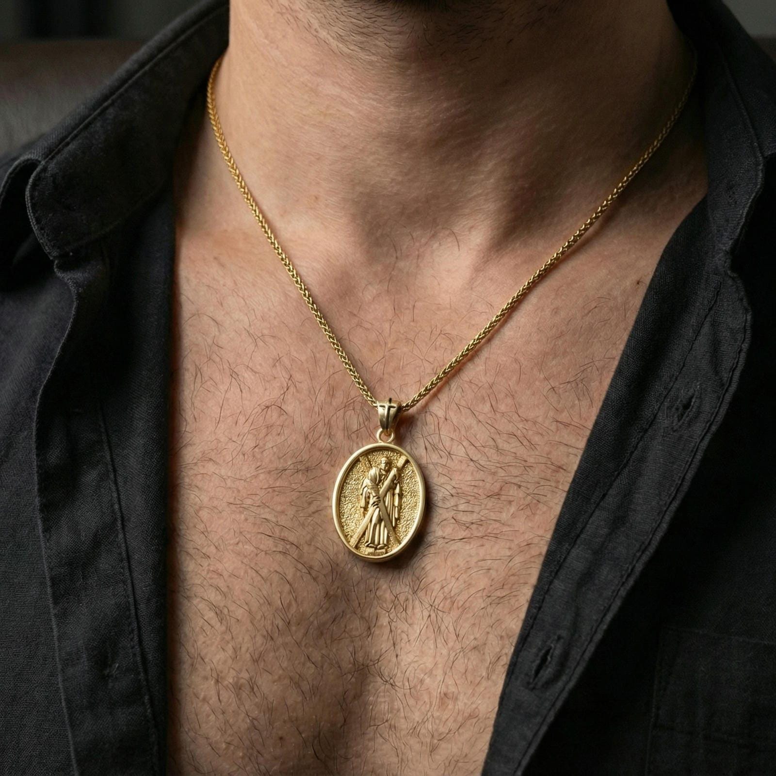Gold plated Saint Andrew oval pendant necklace on neck, warm highlights, premium lifestyle composition, religious jewelry focus