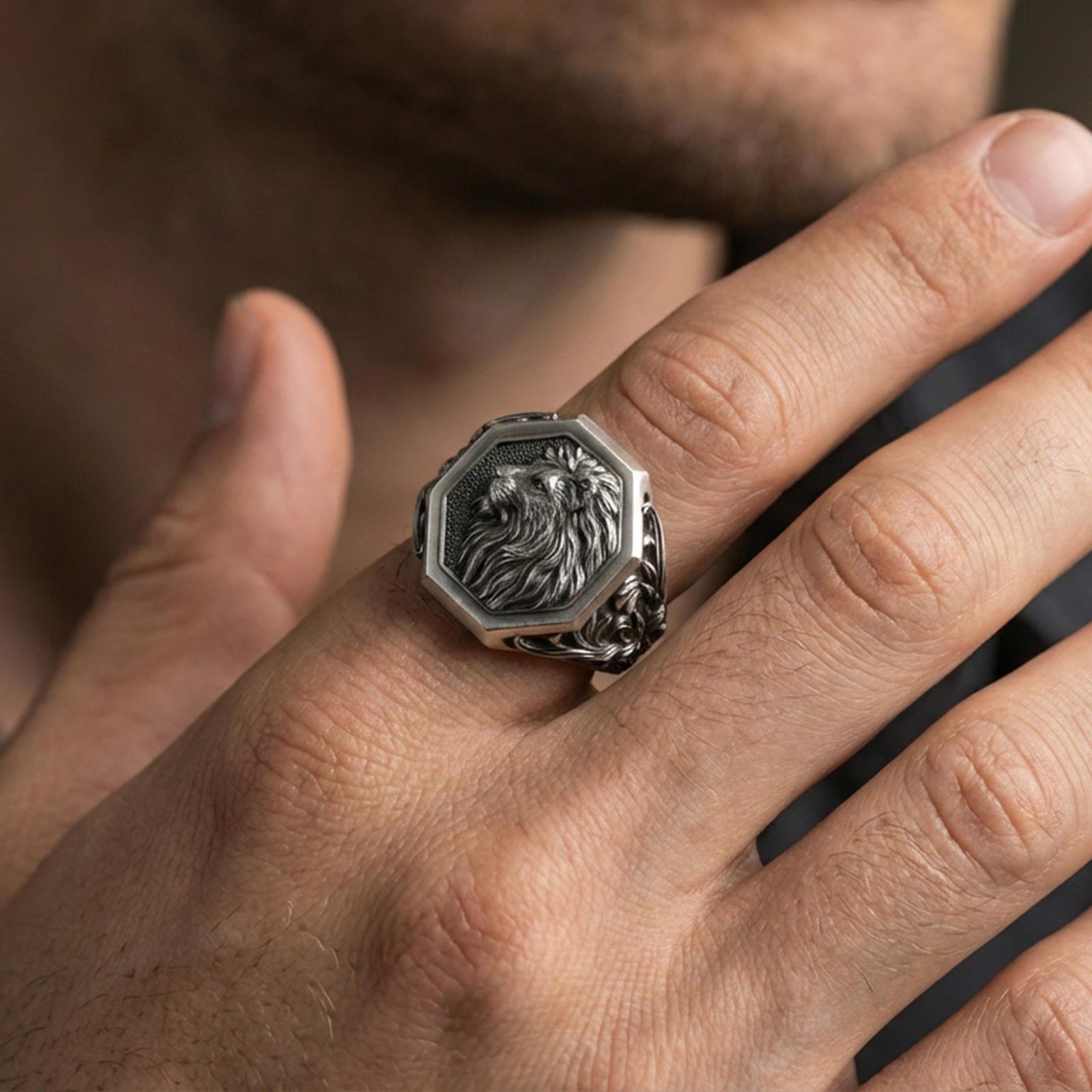 Oxidized octagon lion signet ring worn on finger, lifestyle close-up highlighting raised lion profile and ornamental side engravings