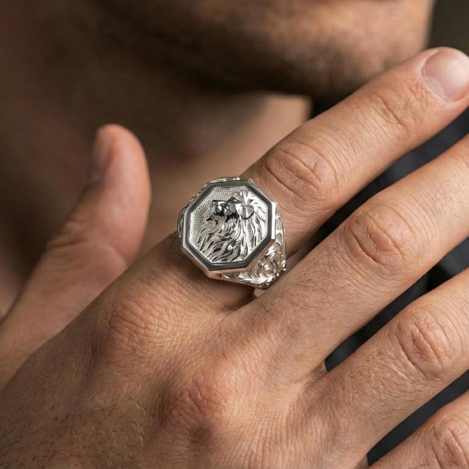 Polished silver octagon lion signet ring worn on finger, lifestyle hand shot showing crisp frame, textured background, and detailed mane depth