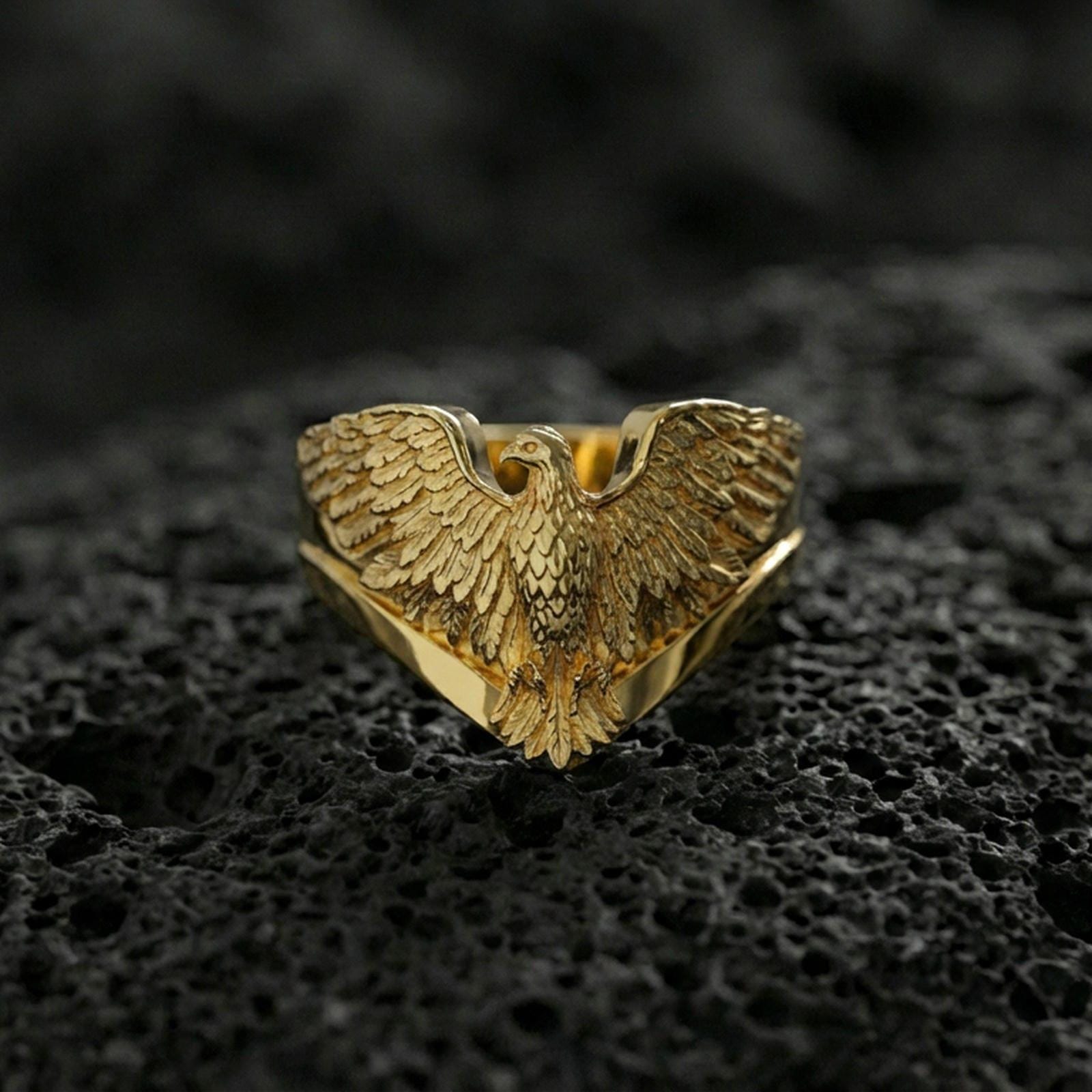 925 sterling silver eagle ring on volcanic stone, gold plated finish emphasizing the eagle’s spread wings and sculpted feather texture