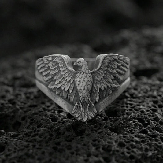 925 sterling silver eagle ring on volcanic stone, oxidized finish highlighting the layered feather engraving and spread wings