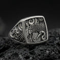 Load image into Gallery viewer, 925 sterling silver crane signet ring on volcanic stone, oxidized finish highlighting the engraved feathers, floral accents, and textured background
