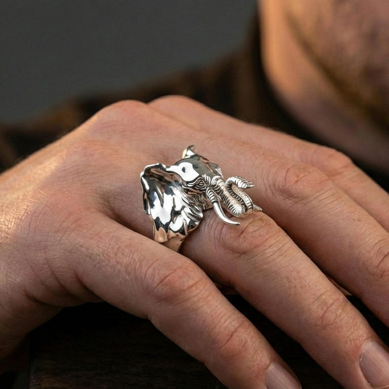 Polished silver elephant ring on finger, natural hand pose highlighting the sculpted head and textured finish