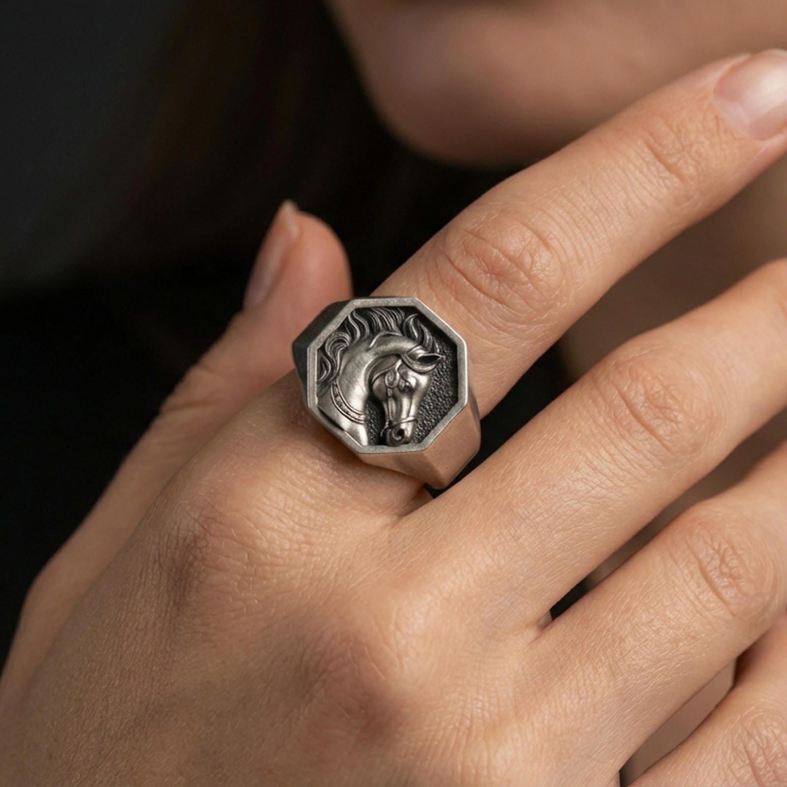 Oxidized horse signet ring worn on finger, lifestyle close-up showing the octagon face and engraved stallion head