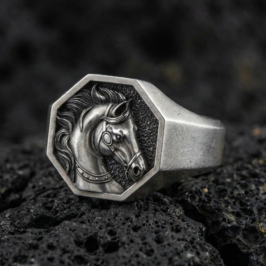 Oxidized sterling silver horse signet ring on textured volcanic rock, octagon face with detailed stallion portrait in macro studio shot