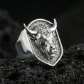 Load image into Gallery viewer, Polished silver bull head signet ring on volcanic rock surface, studio close-up highlighting crisp edges and detailed facial engraving
