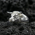 Load image into Gallery viewer, Polished silver bull ring on volcanic rock surface, close-up highlighting realistic facial sculpting and smooth band profile
