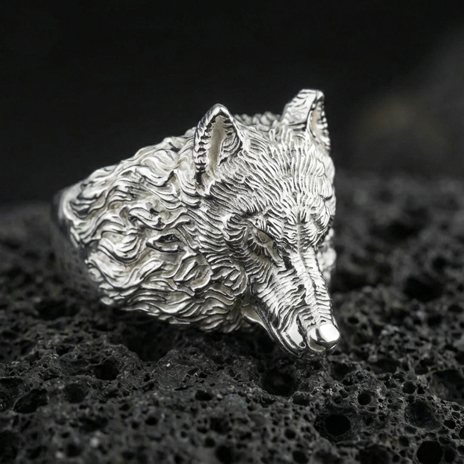 Polished silver wolf ring on volcanic stone, 3D animal head design with premium studio lighting