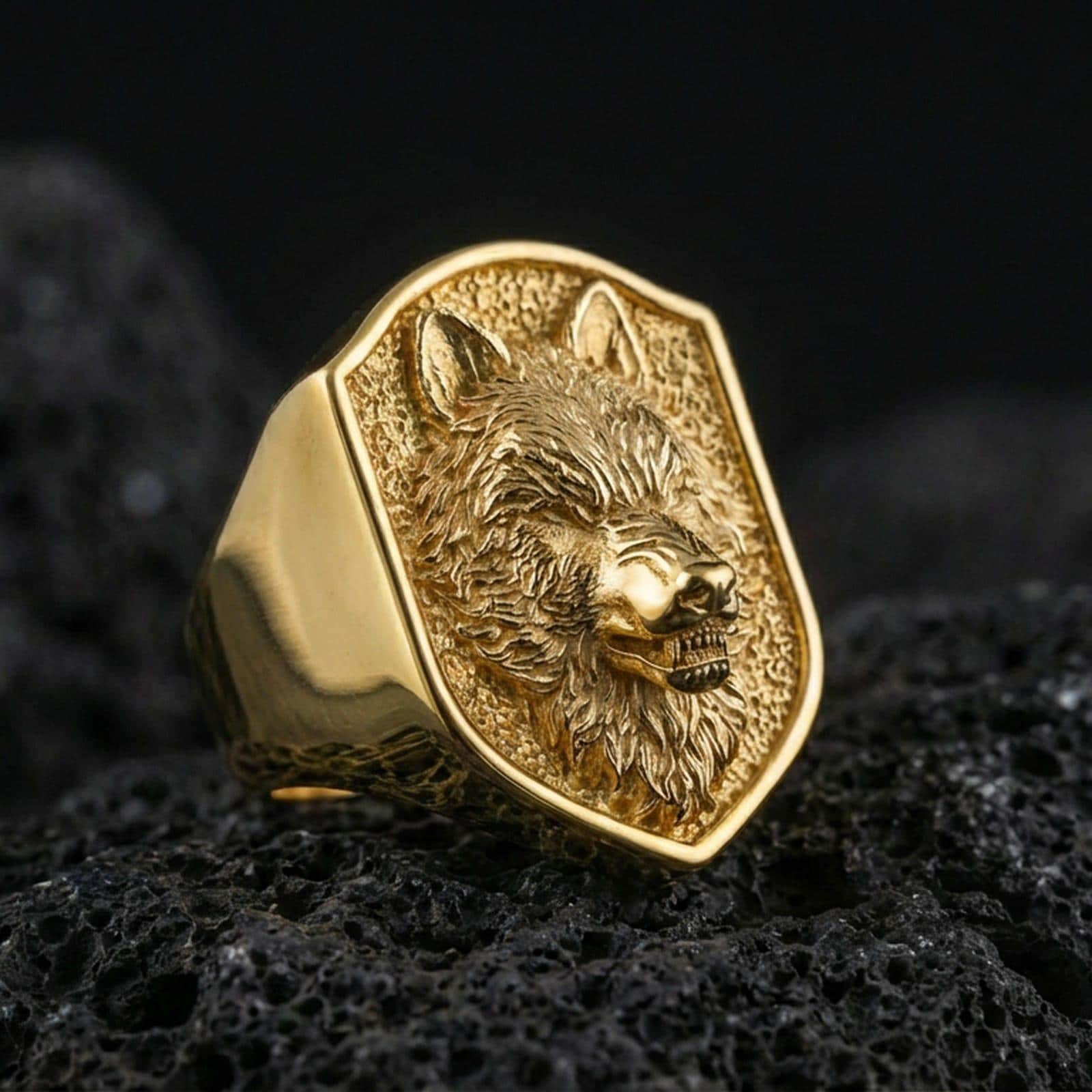 Gold plated wolf signet ring on volcanic stone, bold animal face ring closeup