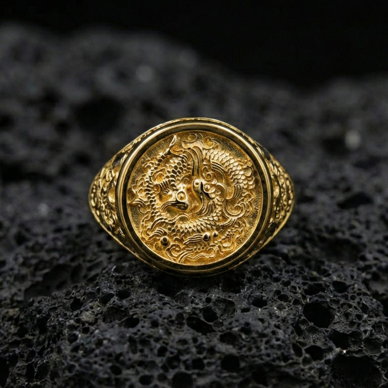 Gold plated koi fish signet ring on porous volcanic stone, premium dark background emphasizing the sculpted fish scales and ornate circular top