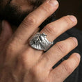 Load image into Gallery viewer, Polished silver owl ring on finger, natural hand pose highlighting the wide wing design and textured owl body relief
