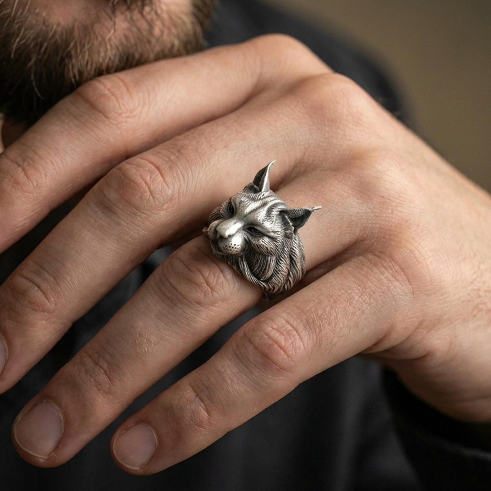 Oxidized lynx ring worn on finger, lifestyle close-up focusing on the realistic feline profile and engraved fur texture