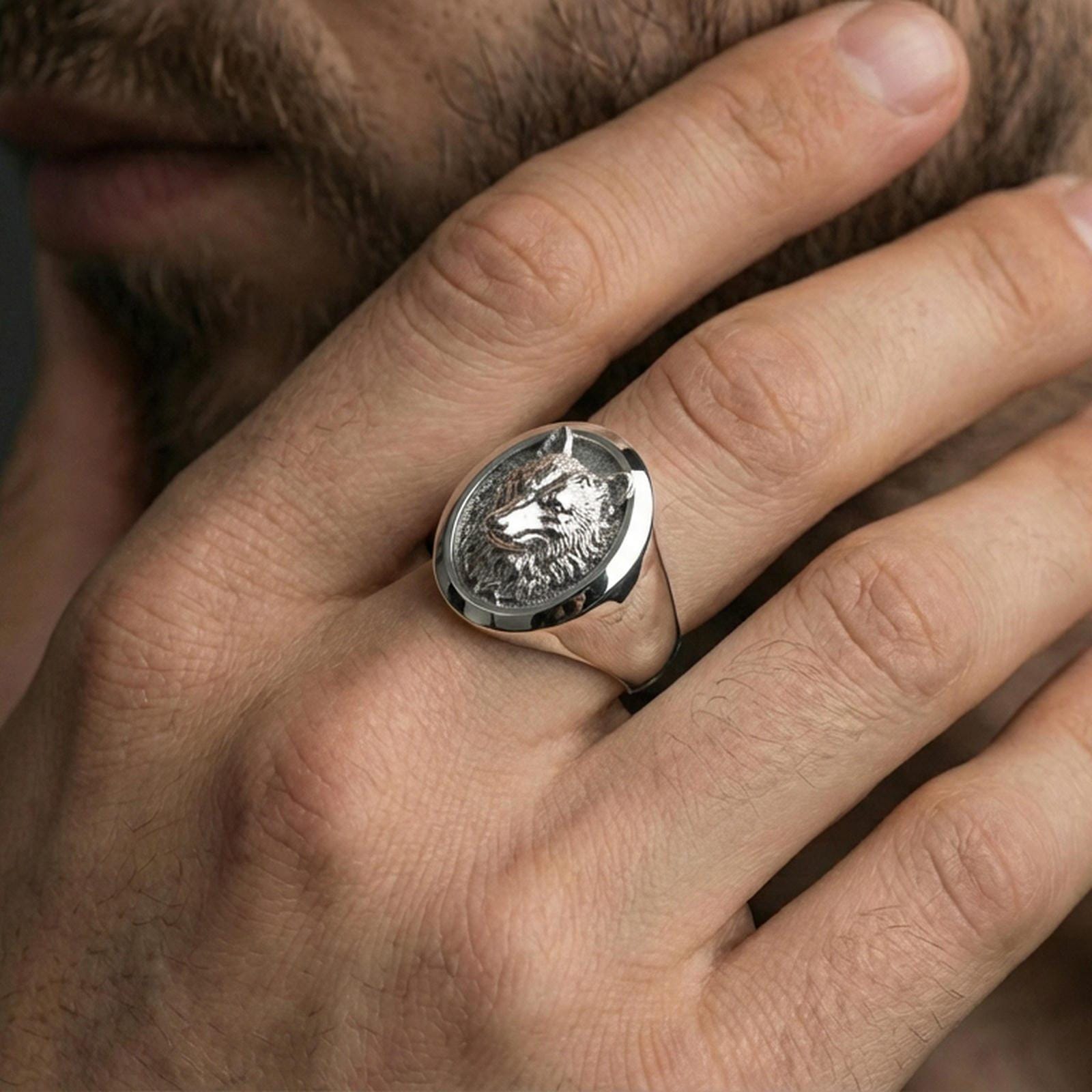 Polished silver wolf head ring on hand, everyday statement style with oval signet silhouette