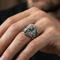 Load image into Gallery viewer, Oxidized elephant signet ring worn on finger, lifestyle close-up focusing on the frontal elephant face, tusks, and wide statement top

