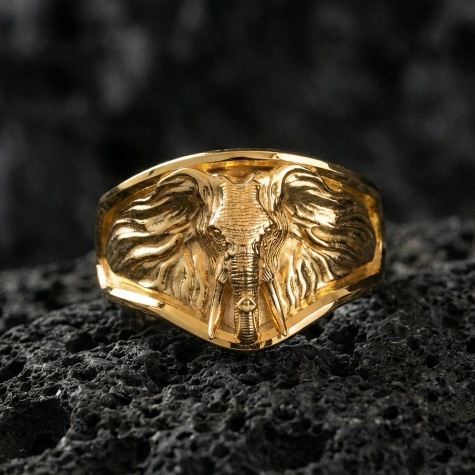 Gold plated elephant signet ring on porous volcanic stone, premium dark studio shot emphasizing the detailed ears, tusks, and bold safari-inspired relief
