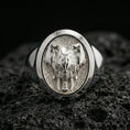 Load image into Gallery viewer, Polished silver elephant head signet ring on volcanic rock surface, close-up highlighting the oval bezel, textured background, and clean band profile
