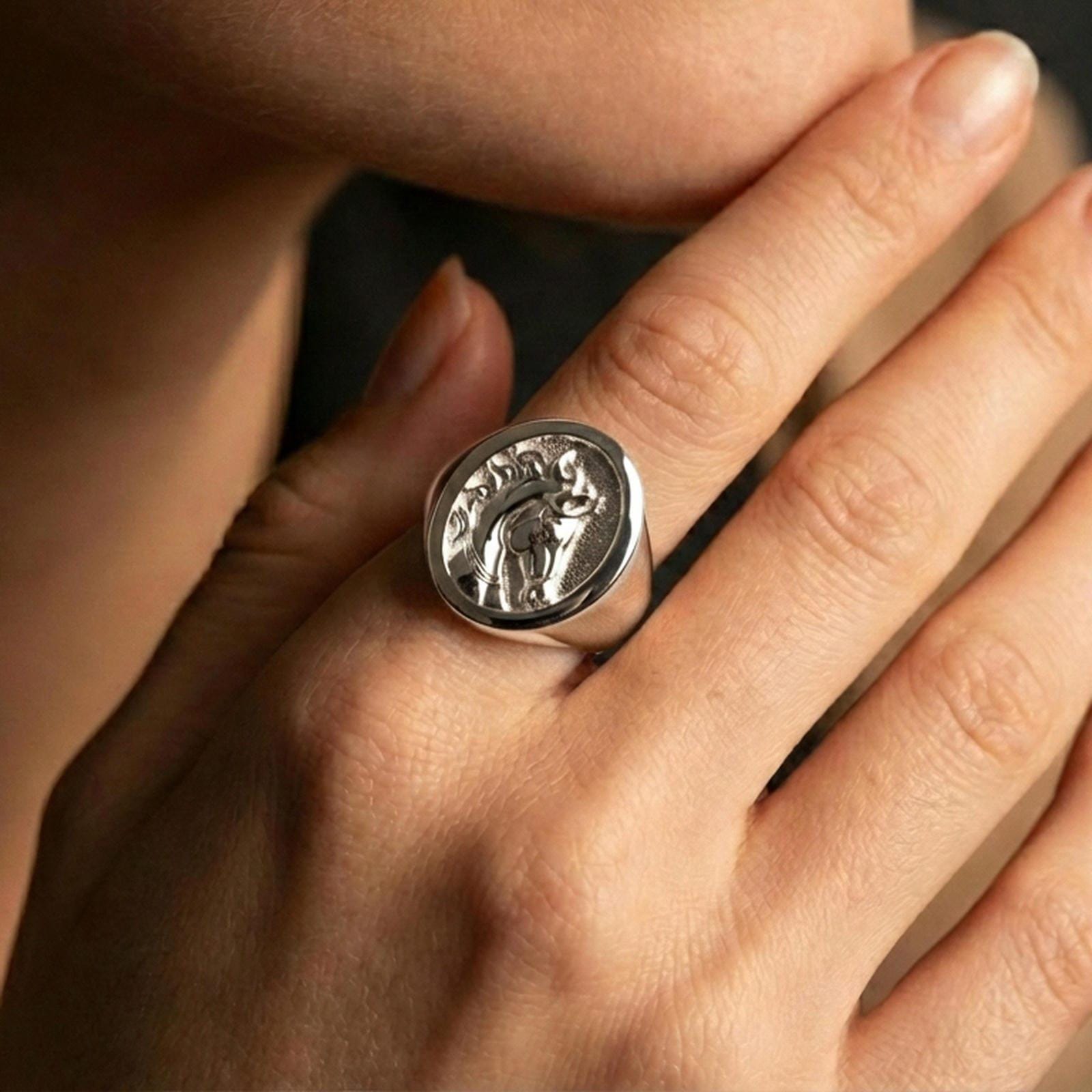 Polished silver horse ring on finger, natural hand pose highlighting the carved mane, round bezel edge, and classic signet profile