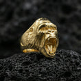 Load image into Gallery viewer, Gold plated gorilla head ring on black volcanic stone, macro view highlighting the roaring mouth and texture
