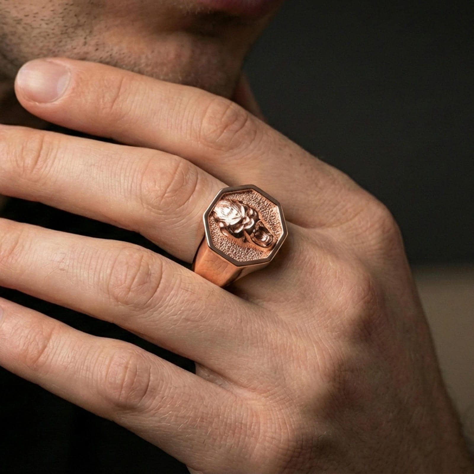 Rose gold plated gorilla signet ring worn on a finger, close-up showing the octagon frame and deep engraving look