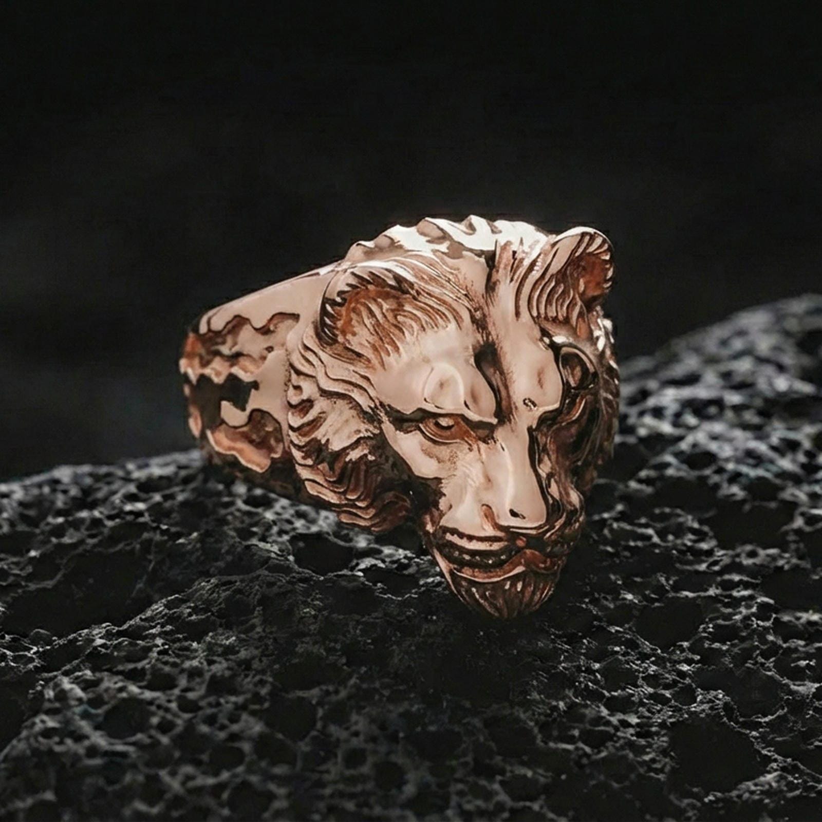 Rose gold plated lioness ring on porous volcanic rock with dramatic contrast and premium studio lighting