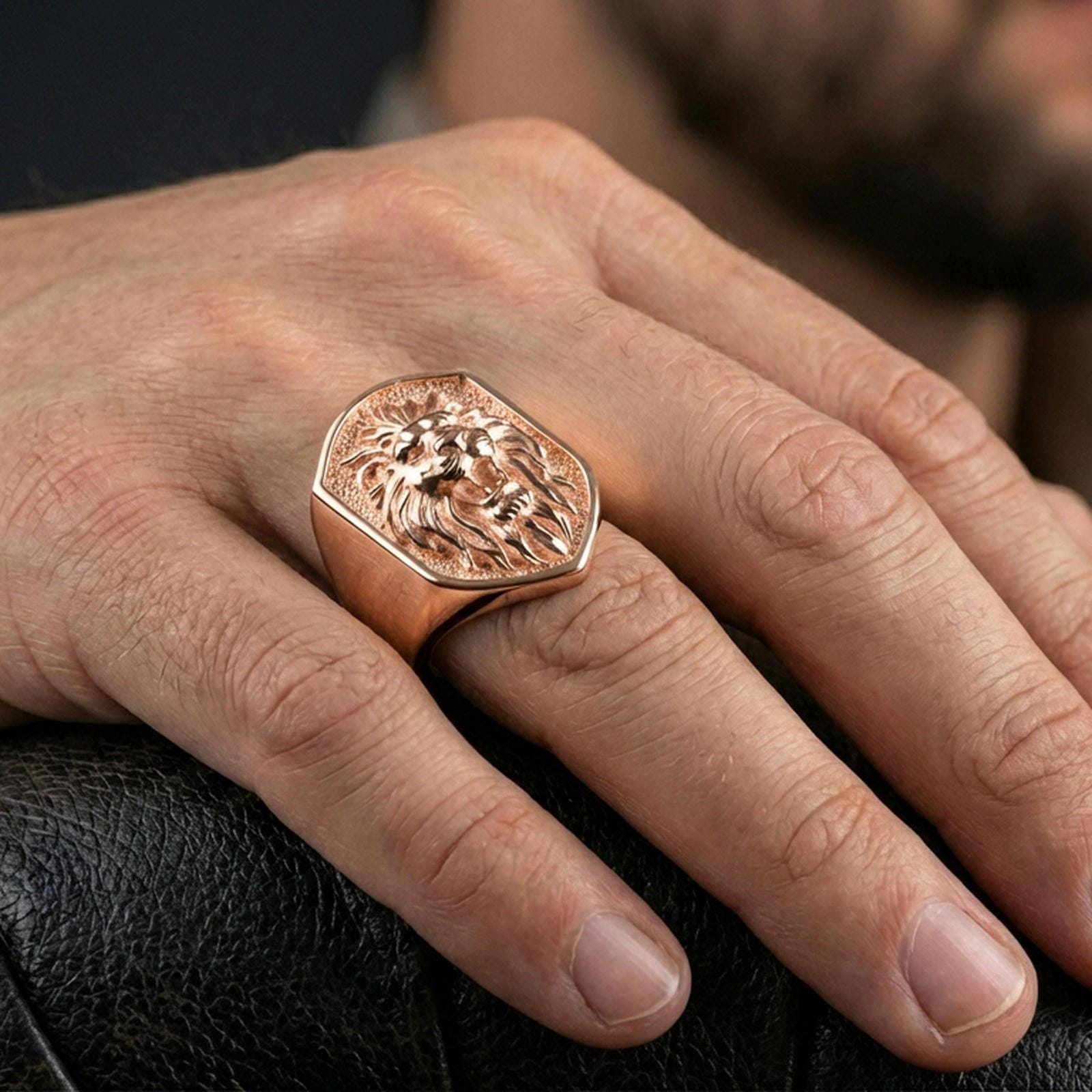 Rose gold plated roaring lion signet ring worn on a finger, macro angle showing the sculpted details and depth