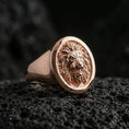 Load image into Gallery viewer, Rose gold plated lion signet ring on black volcanic rock, premium macro photo showcasing the lion head relief and refined bezel finish
