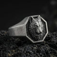 Load image into Gallery viewer, Close-up of an oxidized sterling silver octagon wolf signet ring on porous volcanic rock with dark studio lighting
