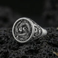 Load image into Gallery viewer, Close-up of an oxidized sterling silver yin yang koi fish signet ring on porous volcanic rock in a dark studio
