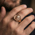 Load image into Gallery viewer, Rose gold plated octagon lion ring worn on a finger, macro shot focused on the lion engraving and texture
