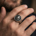 Load image into Gallery viewer, Oxidized sterling silver lion signet ring worn on a finger, front view showing the octagon face and lion portrait
