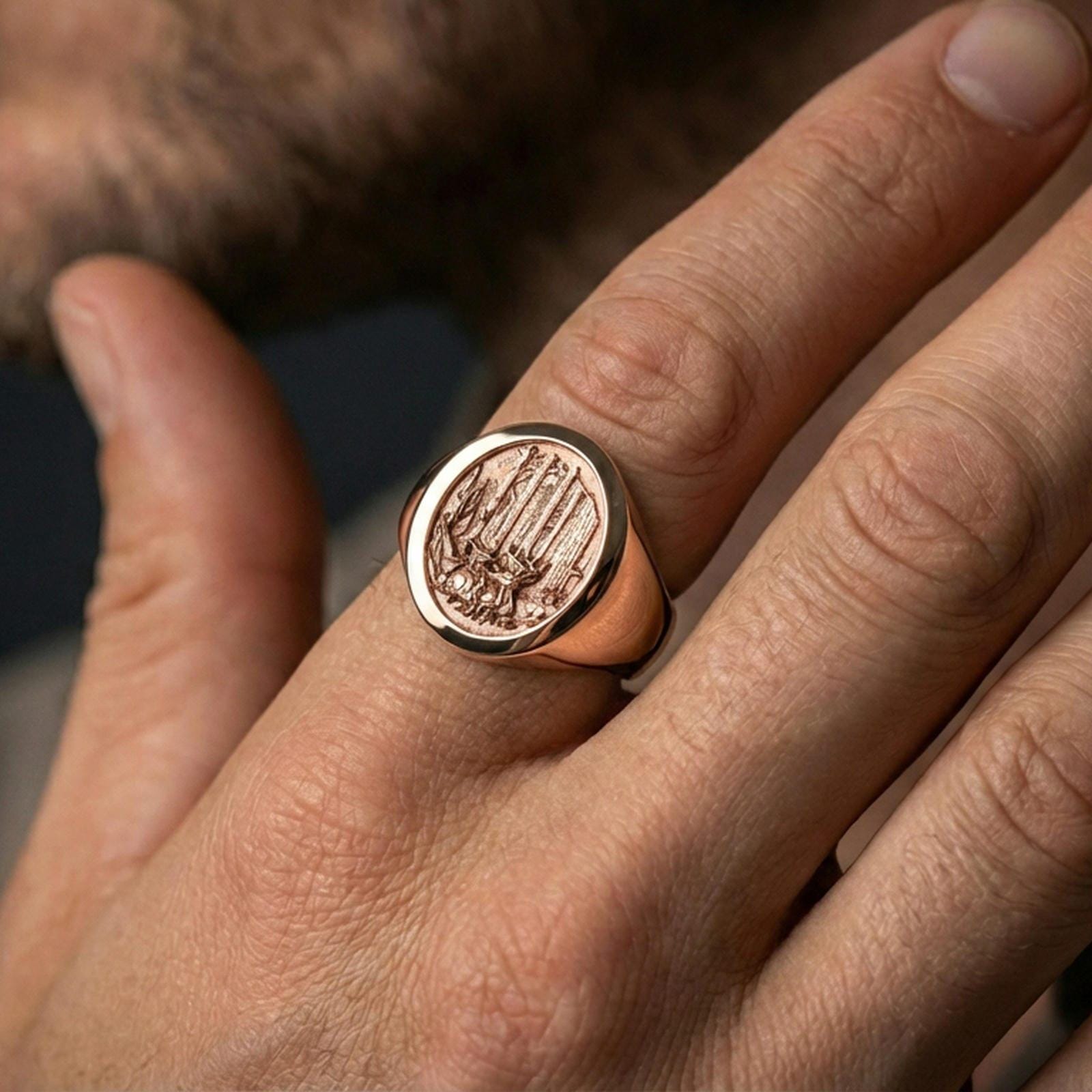 Rose gold plated forest engraved signet ring worn on a finger, close-up highlighting texture and depth