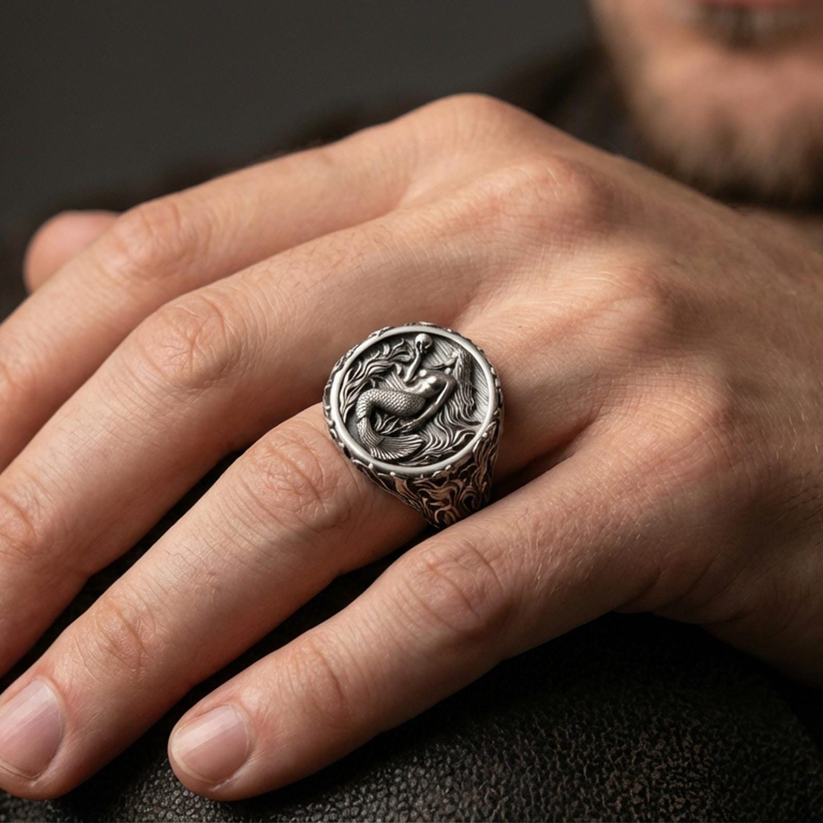 Oxidized mermaid ring worn on finger, dark outfit lifestyle close-up, bold fantasy sea jewelry statement