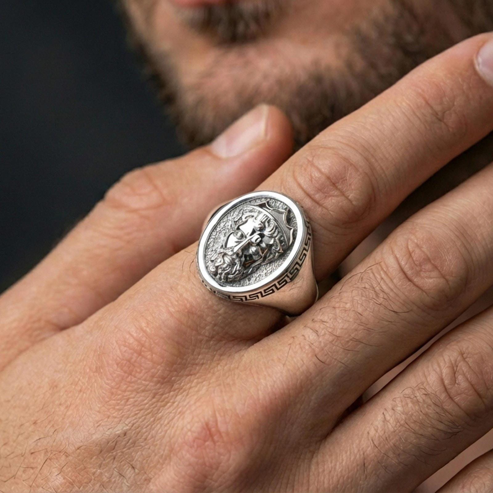 Polished silver Poseidon ring on hand, crowned god portrait detail visible, everyday luxury lifestyle shot