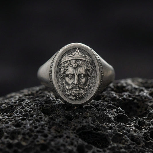 Oxidized Poseidon ring on volcanic rock, Greek god king portrait signet, textured background, macro studio jewelry photo