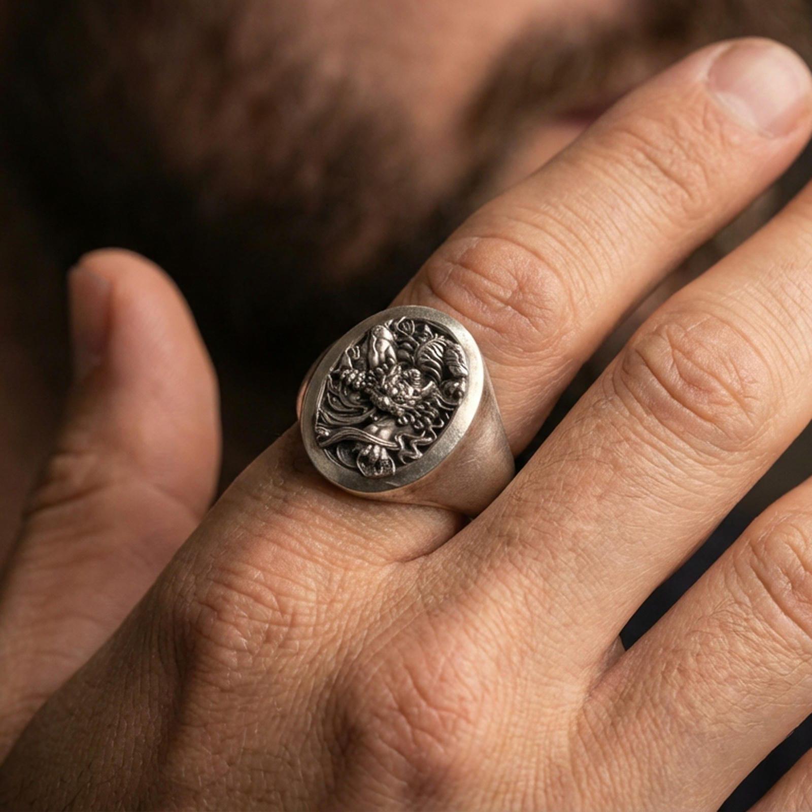 Oxidized signet ring worn on finger, detailed oni/dragon relief visible, lifestyle hand close-up