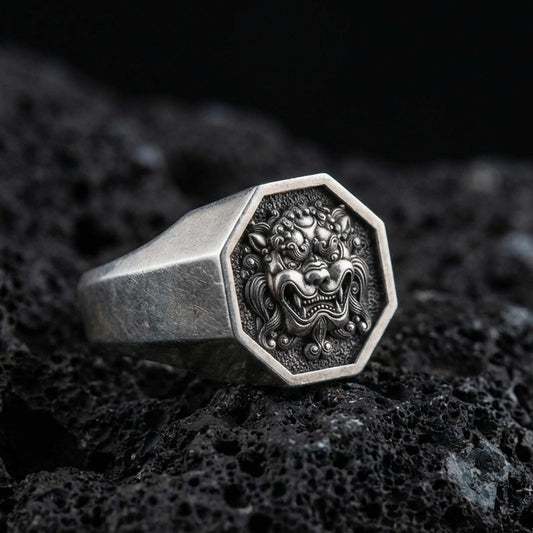 Octagon sterling silver oxidized Foo Dog signet ring on volcanic rock, Chinese guardian lion face relief, macro studio product shot