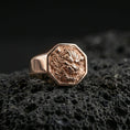 Load image into Gallery viewer, Octagon Foo Dog signet ring in a rose gold plated finish on volcanic rock, ornate guardian lion relief detail, luxury studio close-up
