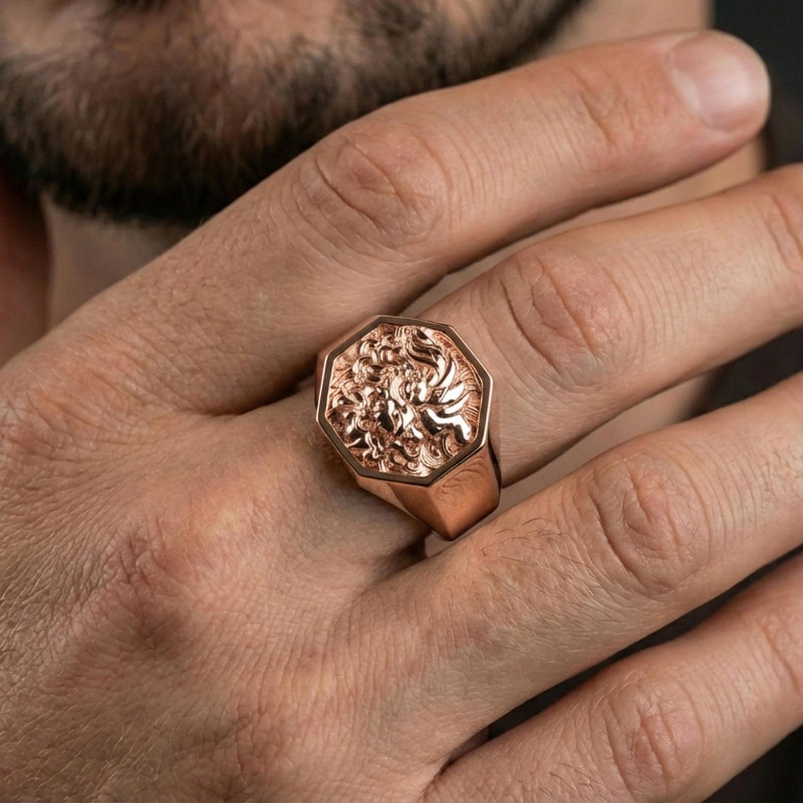 Octagon Foo Dog signet ring in a rose gold plated finish on finger, ornate guardian lion relief detail, lifestyle wear photo