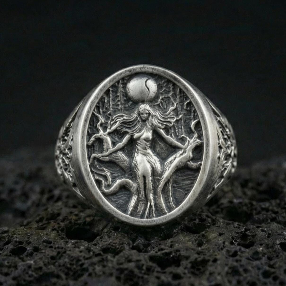Sterling silver Freya Viking ring in an oxidized finish on volcanic rock, Norse goddess figure engraving, macro studio product shot