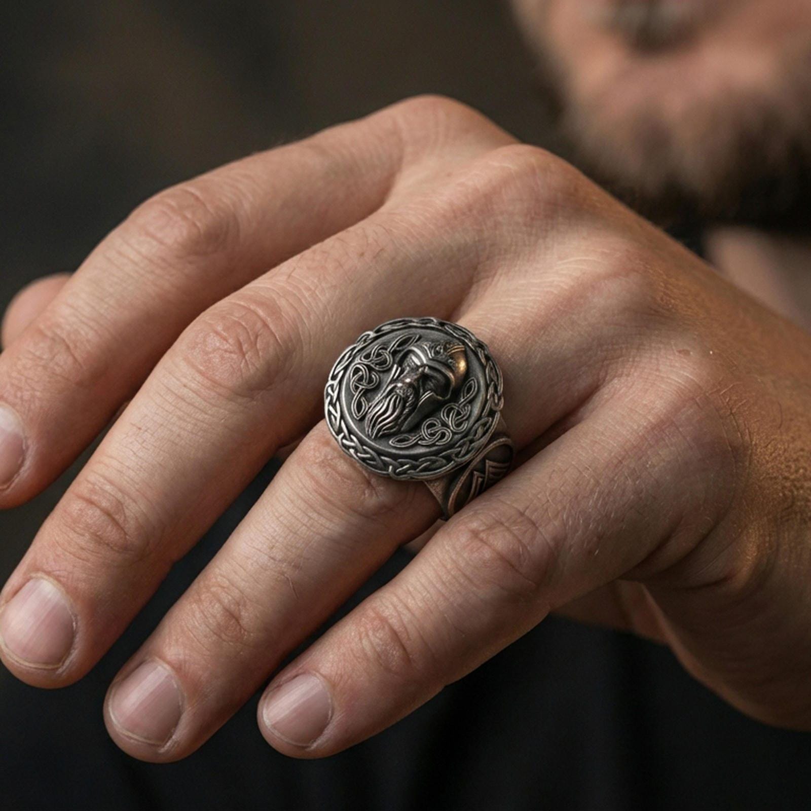 Odin the All-Father sterling silver ring in an oxidized finish worn on finger, Viking portrait and knotwork border visible, lifestyle hand close-up