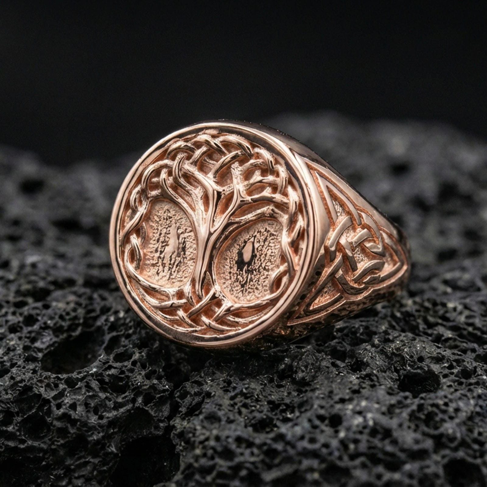 Norse Tree of Life ring in a rose gold plated finish on volcanic rock, Celtic knot band with Yggdrasil engraving, luxury studio close-up
